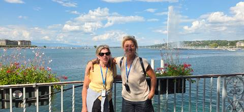       Two women posing in front of a lake and fountain
  