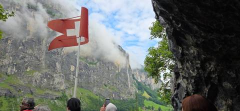       View of mountains with Swiss flag in the foreground
  
