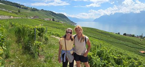       Two women posing in a vineyard with a lake view
  
