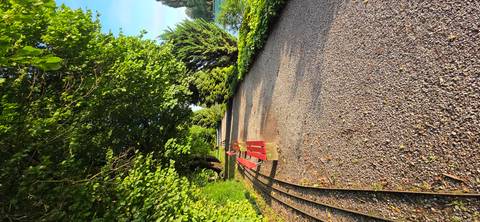       Pebble path through a park with benches and trees
  