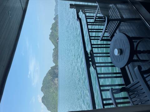       View from a boat deck looking out at limestone islands on calm water.
  
