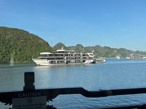       Cruise ships on the water with lush green islands in the background.
  