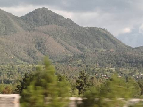       Out of focus landscape with mountains and greenery.
  