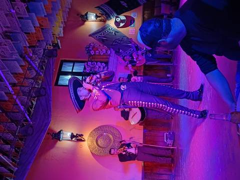 Musician in traditional Mexican attire performing on stage.