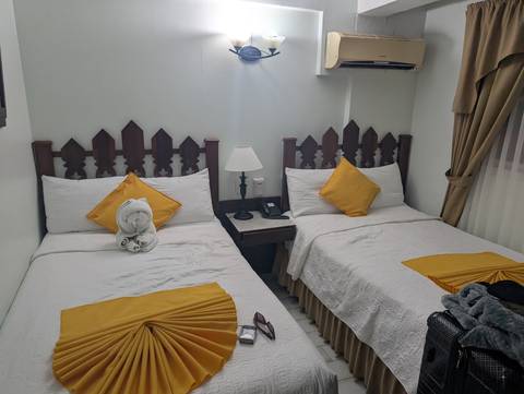 Simple hotel room with two beds and colorful pillows