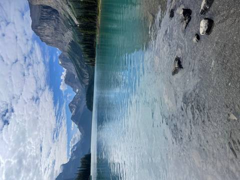 A serene lake with clear turquoise waters surrounded by high mountains.