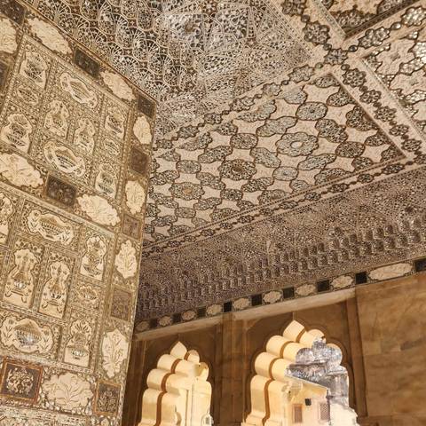 Ornate ceiling and wall decorations at Amer Fort in Jaipur.