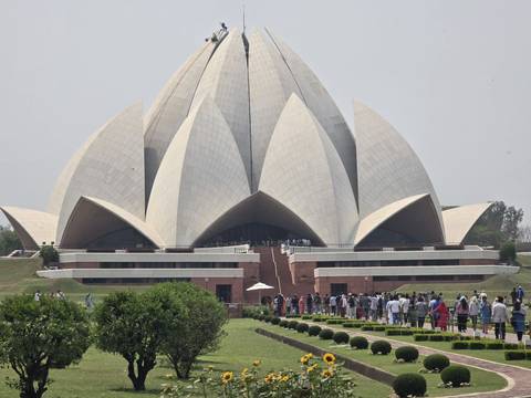 Lotus Temple in New Delhi surrounded by green gardens.
