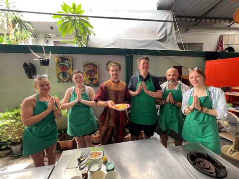Group of people posing in a cooking class environment.