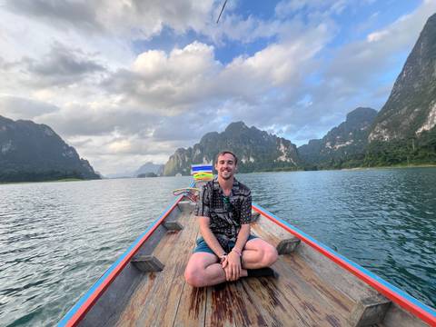 Person sitting on a boat with limestone karsts in the background.