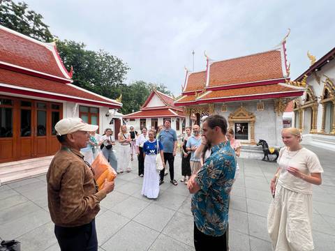 Tour group in front of traditional temple buildings.