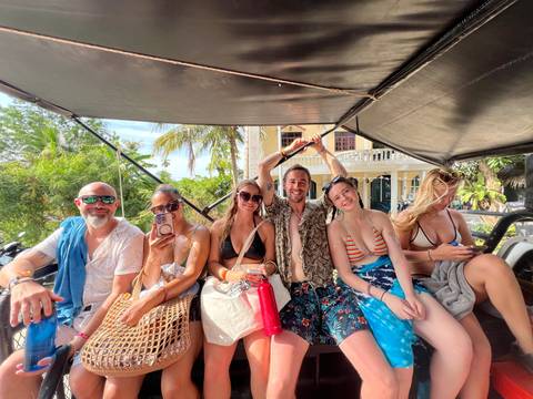 Group of people in an open vehicle, smiling and relaxed.