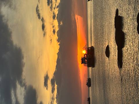 Boats on the ocean with a vivid sunset.