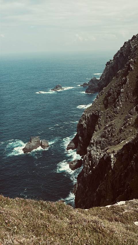 Coastal cliffs with rough sea waters below.