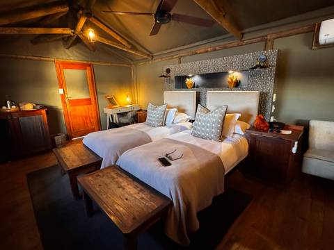 Interior of a safari lodge with twin beds.