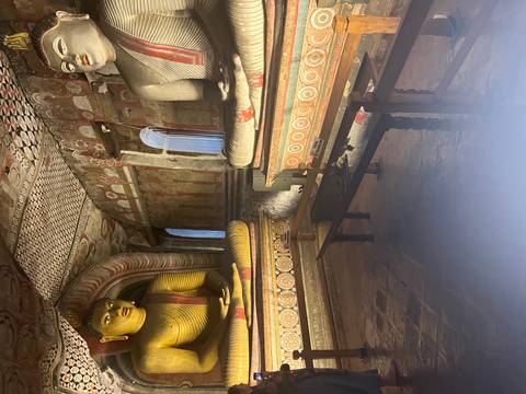Interior of a temple with Buddha statues and murals.