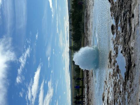Geyser eruption under a clear sky.