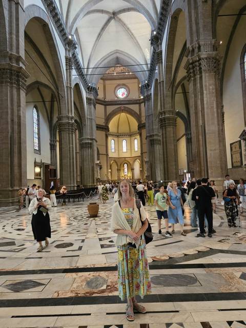 Interior of a grand cathedral with tourists.