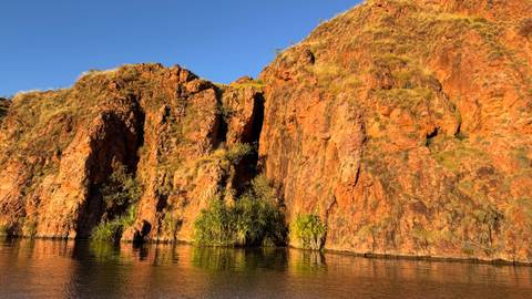 Orange cliffs reflecting in water.