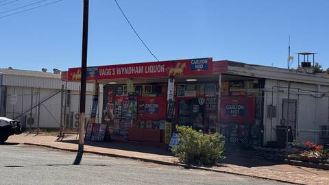 A liquor store with signs on the facade.