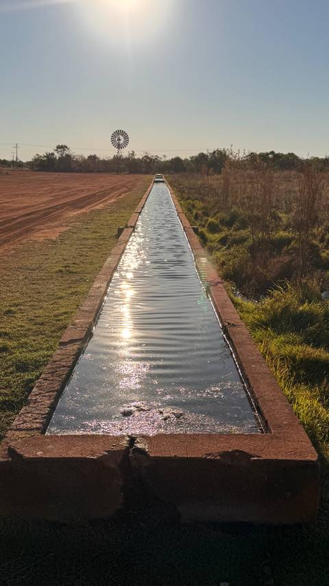      A water channel aligned with grass on the sides.
  