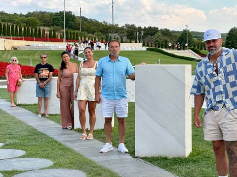 A group of people standing near a monument in a park.
