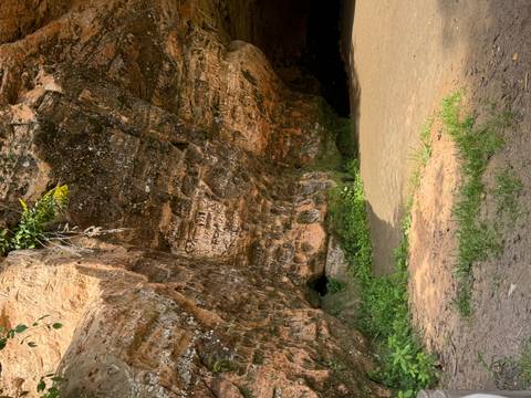       Rock formation with carvings and an entrance.
  