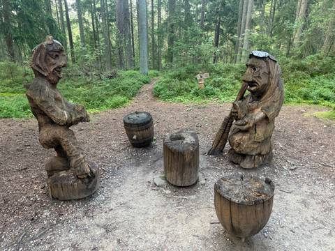       Wood sculptures in a forest clearing.
  