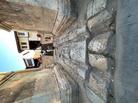       Ancient city ruins with tourists exploring.
  