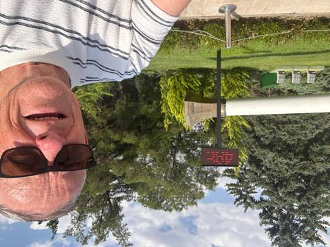       A person in front of a sculpture and electronic sign.
  