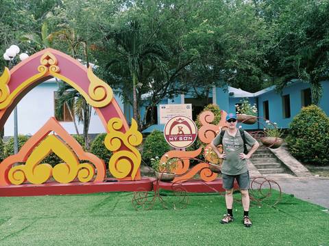       Man posing near My Son site signage.
  