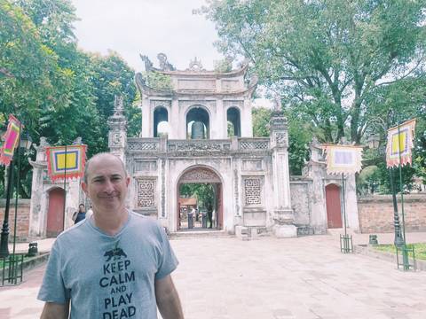       Man standing in front of a historical gate.
  