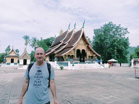       Man posing in front of a temple complex.
  