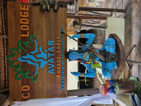 Statue of a blue character next to a sign for Avatar Amazon Lodge.