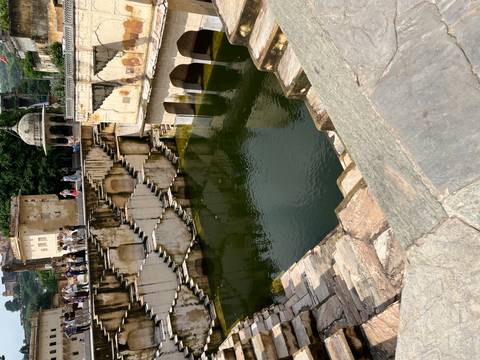 Tourists exploring an ancient stepwell with stairs.