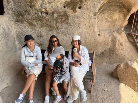 Family sitting on a bench inside a cave.