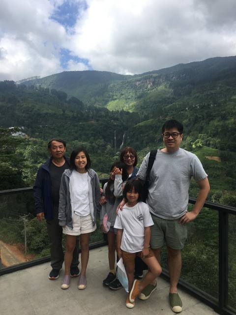 Family posing with a waterfall in the background.