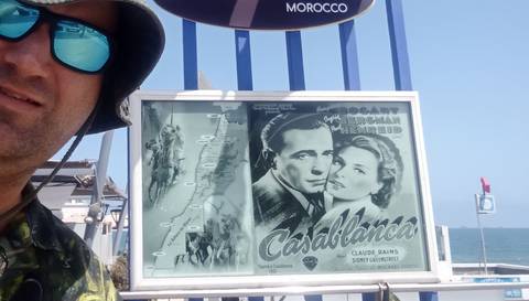 Person taking a selfie in front of a mosque tower.