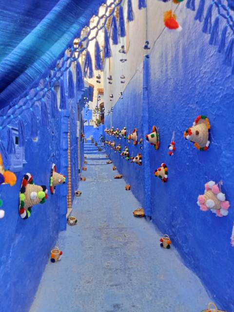 Blue-painted narrow alley with steps leading up.
