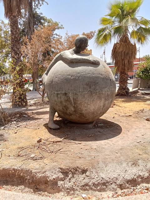 Monumental arch with a tram passing through.