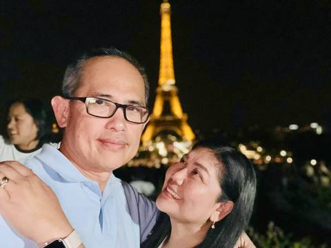       Couple posing at night with the Eiffel Tower illuminated in the background.
  