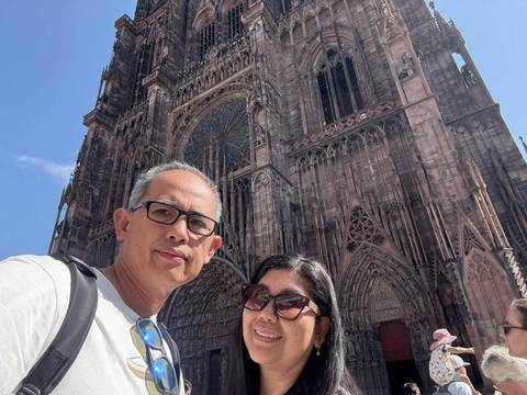 Couple posing in front of a cathedral facade.