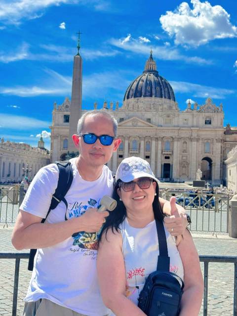 Couple posing in front of St. Peter's Basilica.