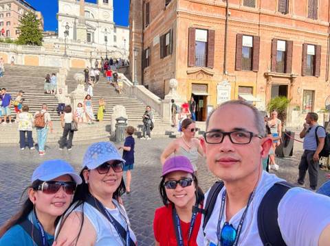       Group of tourists posing on the Spanish Steps.
  