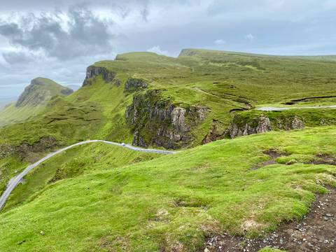 Scenic mountain road with lush greenery.