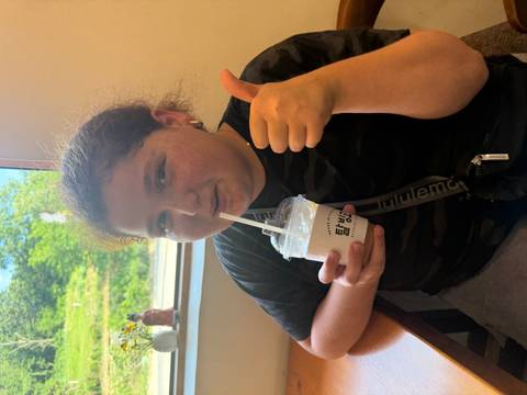 Person inside with a drink, giving a thumbs up.