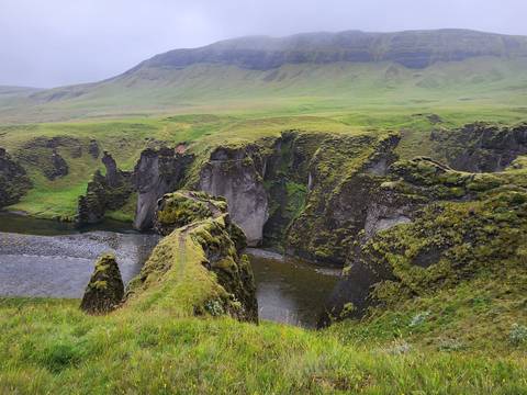 Lush green cliffs above a river.
