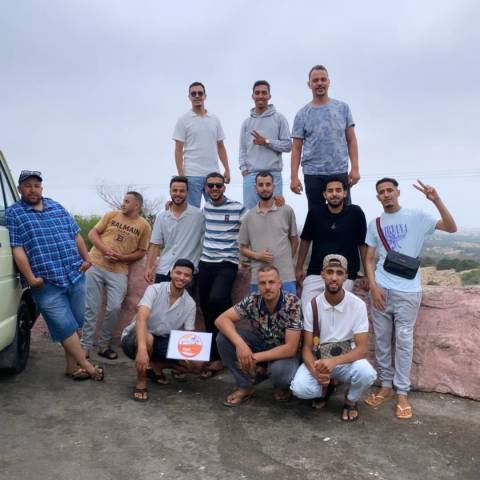       Group of young men posing together on a clear day.
  
