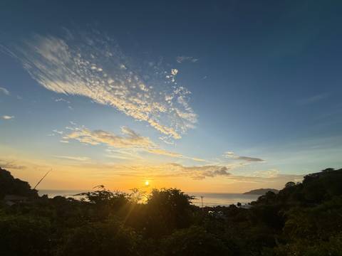       Sunset view over the ocean with clouds and horizon.
  
