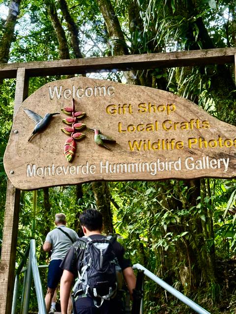       Sign for Monteverde Hummingbird Gallery with decorative elements.
  
